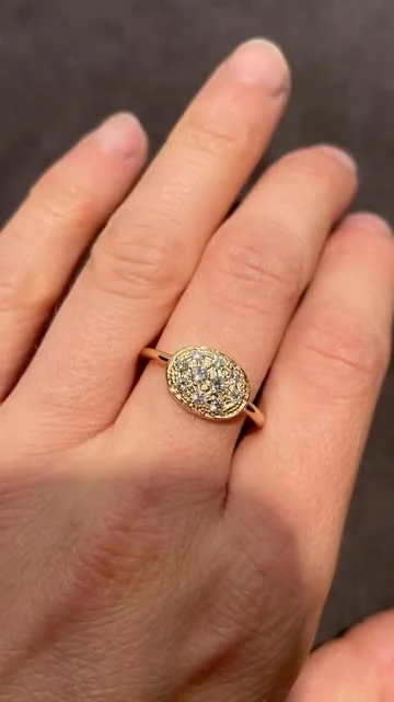 Bague ovale pavée de petites pierres portée sur une main