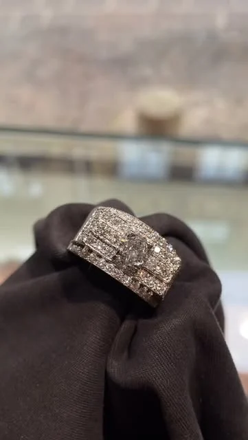 Bague large à plusieurs rangs de pierres lumineuses sur une étoffe noire